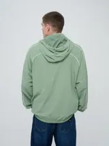 Campera rompevientos Umbro modelo Venti, de color negro con líneas blancas en las mangas y hombros, capucha con cordón de ajuste y cierre frontal completo. Cuenta con el logo de la marca bordado en el pecho.