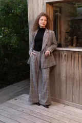 Pantalón sastrero de tiro alto con estampa a cuadros en tonos grises, rojos y blancos, de corte recto y holgado.