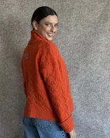 Sweater de lana color crudo con cuello alto y diseño trenzado.