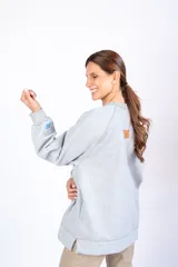 Buzo gris de calce oversize con cuello redondo y mangas largas. Presenta el logo de la marca bordado en el frente y un parche con la bandera de Uruguay en la manga izquierda.