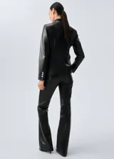 Pantalón de tiro medio confeccionado en 100% piel de ovino, con diseño largo de estilo flare y forro interior.