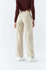 Pantalón marrón de cuero sintético, tiro medio, corte recto cropped y detalle de costuras verticales.