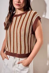 Chaleco de punto sin mangas con diseño de rayas verticales en tonos marrón, blanco y mostaza. Presenta cuello redondo y terminaciones acanaladas en color marrón sólido.