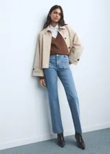 Jeans flare de tiro medio color celeste, confeccionados en tejido denim de algodón con elasticidad. Presentan cierre delantero con cremallera y botón, trabillas para cinturón y dos bolsillos de parche en la parte delantera.