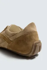 Zapatilla de cordones color beige, con parte superior de piel con acabado serraje y detalles de pespuntes. Suela ultrafina a contraste.