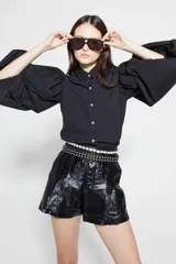 Camisa negra de popelina de algodón con cuello clásico, botones de nácar y mangas largas abullonadas.