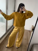 Conjunto de dos piezas compuesto por un buzo de cuello redondo y mangas largas con diseño reversible y un pantalón de corte ancho con cintura elástica.
