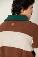Buzo tejido de punto con diseño a rayas horizontales anchas en color marrón y beige. Presenta un cuello polo en color verde oscuro con cierre frontal de dos botones, mangas largas con puños elásticos y un corte boxy fit.