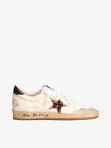 Zapatillas deportivas de cuero color blanco hueso con detalles en negro y estrella de animal print.