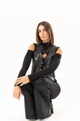 Chaleco de cuero con acabado desgastado, estilo western, con cierre frontal de botones metálicos y detalles de ojalillos con entrelazado de cuero en la parte superior delantera.