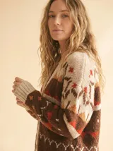 Cardigan de punto con diseño fair isle en tonos chocolate, ladrillo, naranja quemado y crema, de manga larga y escote en V.