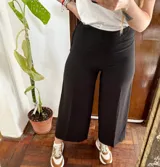 Pantalón de vestir H&M de color negro, corte ancho tipo palazzo y largo midi por encima de los tobillos.