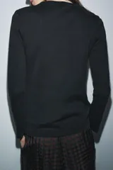 Camiseta de manga larga confeccionada en tejido de punto interlock elástico y flexible, con cuello redondo y bajo recto.