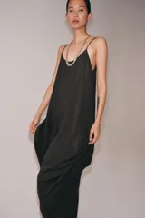 Vestido midi de tirantes finos con escote redondo, confeccionado en mezcla de viscosa y lino. Presenta un diseño con volumen, detalle de pliegues frontales y bajo asimétrico.