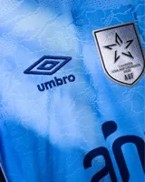 Camiseta de fútbol Umbro del Club Nacional de Football, edición especial de color celeste con detalles en azul marino y blanco. Incluye el escudo del club bordado con tres copas arriba, logo de Umbro, y sponsors BBVA y Antel.