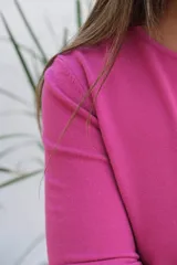 Sweater de punto color magenta, con cuello redondo, manga larga con puños acanalados y corte holgado.