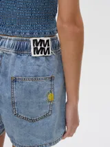Short de denim color tostado, de corte relajado con cintura elástica y cordón ajustable. Posee un bolsillo trasero con un pequeño bordado de sol.