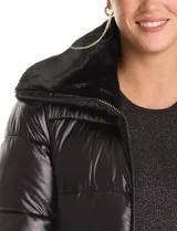 Campera puffer larga de acabado satinado en color beige. Presenta un diseño capitoneado horizontal, cuello amplio revestido en piel sintética, cierre frontal bidireccional y bolsillos laterales con cremallera.
