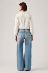 Pantalón de jean con corte bootcut y ajuste holgado, de tiro medio y lavado azul claro con efecto desgastado.