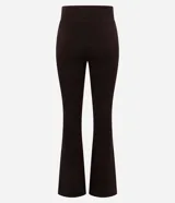 Pantalón flare de tiro alto con cintura ancha, confeccionado en microfibra elástica. Presenta un corte ajustado en caderas y muslos con una silueta acampanada desde la rodilla.