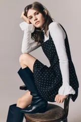 Vestido corto negro con estampado de lunares blancos, escote cuadrado, breteles anchos, cuerpo entallado y falda evasé con vuelo.
