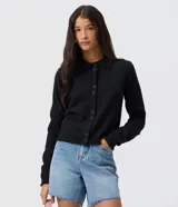 Saco de tricot negro de corte regular, con cuello polo, mangas largas y cierre frontal con botones. Presenta un diseño clásico y versátil.