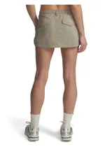 Short pollera Under Armour de color beige, confeccionado en tejido ripstop ultrarresistente y ligero, con acabado brillante. Cuenta con cintura elástica, bragueta funcional con botón a presión, bolsillos cargo laterales y bolsillos traseros con solapa.