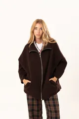 Tapado tipo poncho de color chocolate, confeccionado en tejido de paño, con cierre frontal completo metálico, cuello alto y bolsillos laterales.