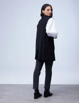 Chaleco largo de punto marca Absolutely Famous, color negro, con cuello de solapa y bolsillos delanteros.