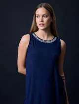 Vestido azul marino de seda fría, sin mangas y escote a la base con aplique de perlas.