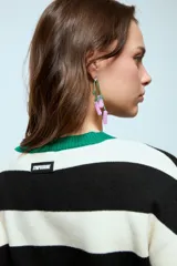 Sweater de punto con diseño de rayas horizontales en blanco y negro, cuello redondo y puños en color verde contrastante.