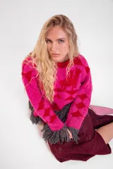 Sweater de lana merino tejido a mano con diseño geométrico y figuras de llamas, corte holgado con cuello redondo y flecos decorativos en el ruedo.