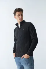 Campera negra de algodón con cierre completo, cuello alto, bolsillos laterales, puños y logo bordado en el pecho.