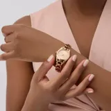 Reloj analógico Guess modelo Veda con caja de 28 mm y malla de eslabones de acero inoxidable en tono oro rosa. Presenta una esfera minimalista con números romanos y acabado pulido.