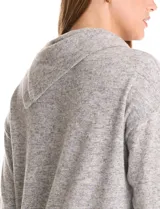 Buzo de calce suelto confeccionado en tejido suave melange color gris. Presenta cuello volcado con botones decorativos en el hombro izquierdo, mangas largas con hombros caídos y ruedo asimétrico con terminación en punta.