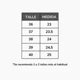 Zapatillas blancas de plataforma, estilo casual con cordones. Presentan un diseño liso con detalles de costuras y un pequeño dije metálico en los cordones.