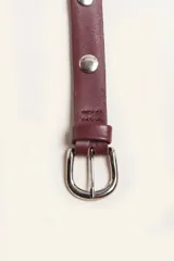 Cinturón de cuero negro con hebilla metálica plateada y tachas circulares.