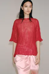 Top rojo de punto con textura efecto arrugado, cuello redondo y mangas cortas holgadas.