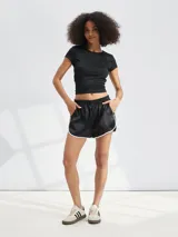 Short negro de satén con cintura elástica y ribetes blancos en los bordes y los laterales.
