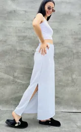 Pollera larga blanca de tela satinada con tajo lateral.