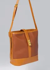 Bolso tipo tote de cuero sintético color marrón, con doble asa corta para llevar al hombro. Tiene un compartimento principal con cierre y un bolsillo interno.