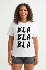 Remera color lila con estampa tipográfica marrón en el frente y mangas cortas.