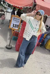 Saco de punto color crema con detalles en crochet verde, cierre frontal con botones y mangas largas.