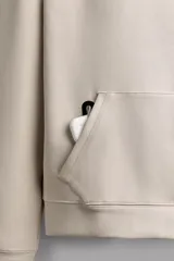 Sudadera de hombre Zara Athleticz de ajuste relajado (relaxed fit), color marrón, confeccionada en tejido técnico compacto con mezcla de algodón y elasticidad. Cuenta con cuello con capucha ajustable con cordones negros, manga larga, bolsillo frontal tipo canguro con un pequeño bolsillo termofijado con cierre, y acabados con rib en puños y cintura.
