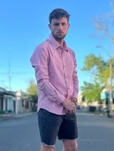 Camisa de manga larga con diseño de rayas finas verticales en color rojo y blanco, de corte clásico con cuello camisero y cierre frontal de botones.