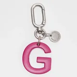 Llavero o charm de letra A en color fucsia, con mosquetón metálico y dije circular pequeño con la marca grabada.