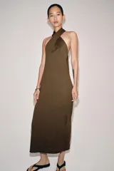 Vestido midi de punto color marrón, con diseño sin mangas, cuello halter cruzado y anudado, y espalda descubierta.