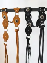 Cinturón marrón con apliques metálicos plateados y negros.