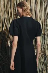 Vestido midi de cuello redondo y manga corta abullonada con terminación elástica. Presenta un diseño de corte entallado en el torso con falda evasé y cierre de cremallera oculta en la espalda.