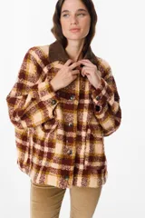 Chaqueta de corte holgado con estampado de cuadros en tonos beige, marrón y amarillo. Presenta cuello camisero en pana marrón, cierre frontal con botones y mangas largas con puños abotonados.